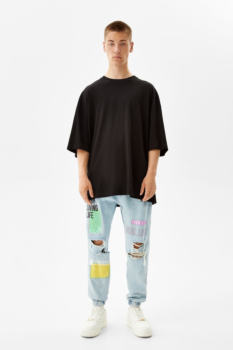 Jeans i joggingstil med print og huller