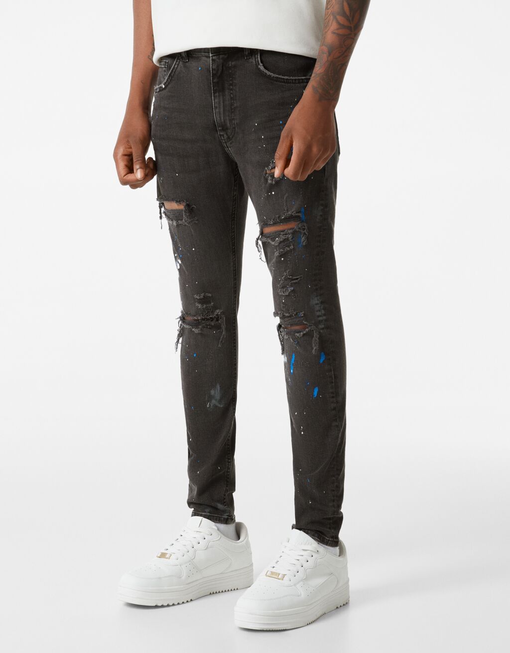 Úzké džíny se skvrnami barvy a roztržením