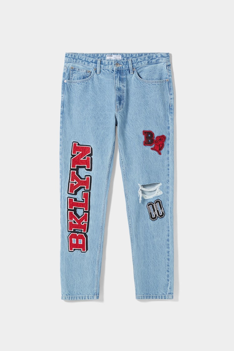 Jeans straight fit dengan tambalan gaya universitas