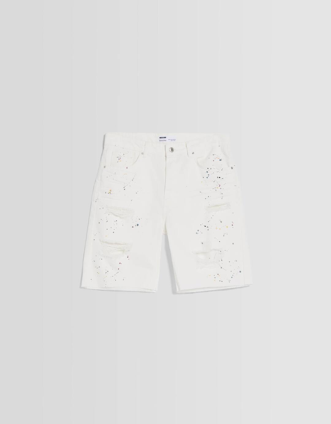 Ripped denim Bermuda shorts with paint splatter