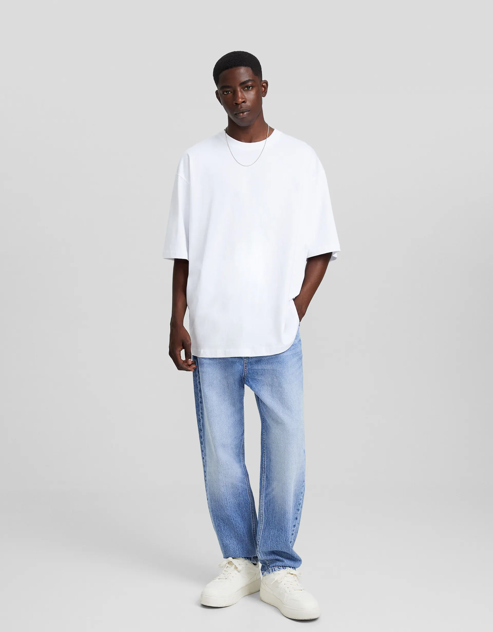 Pull gris oversize en maille épaisse + jean slim blanc + sac