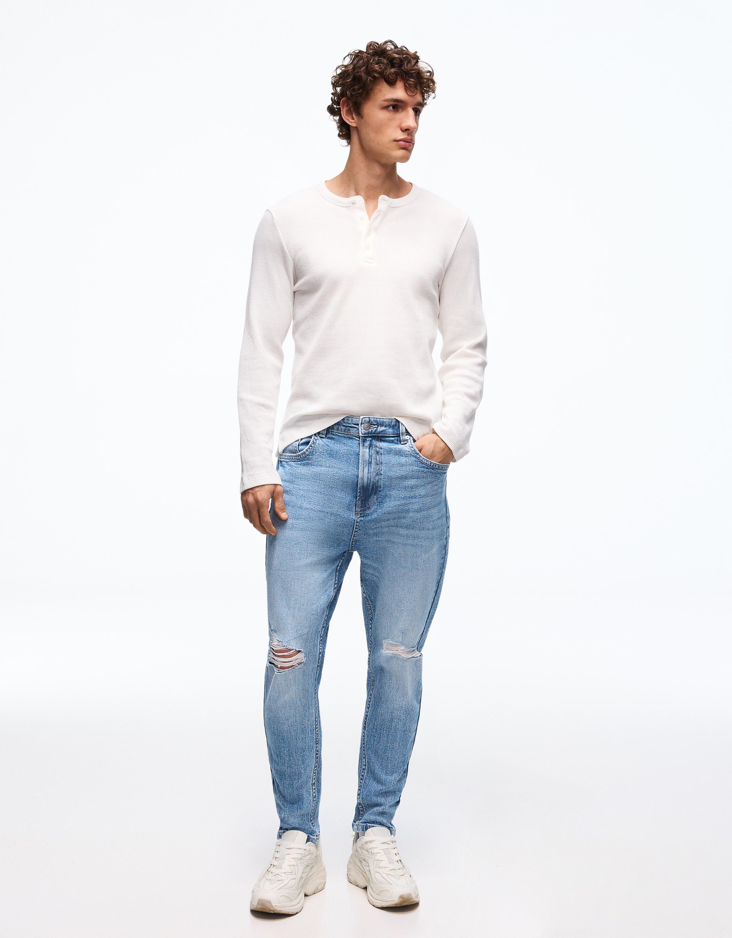 Bershka Jeansy O Kroju Carrot Z Przetarciami Mężczyzna 34 Jasnoniebieski