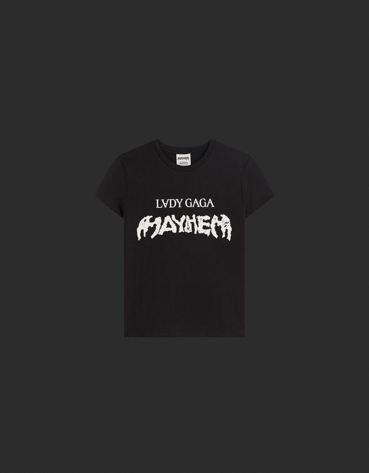 Front view of a black T-shirt with the text "LVDY GAGA MAYHEM" on the chest, short sleeves, and a round neck.