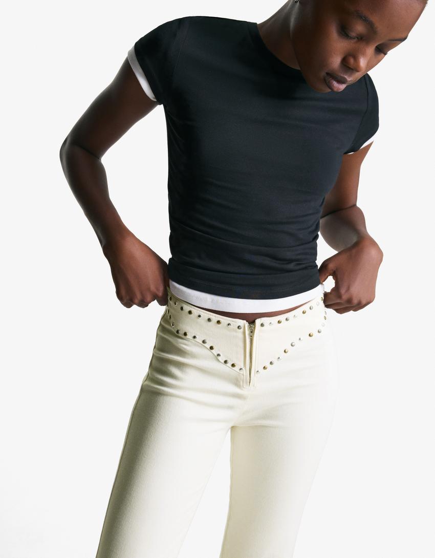 Pantaloni con borchie in vita e cerniera-Bianco Roto