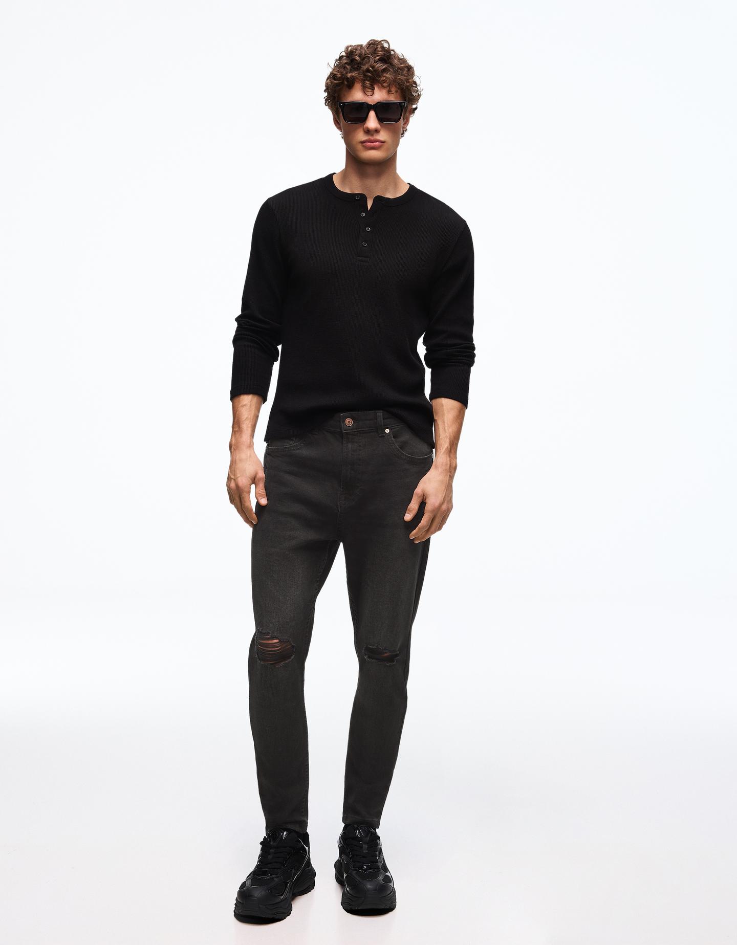 Bershka jeansy o kroju carrot z przetarciami czarny