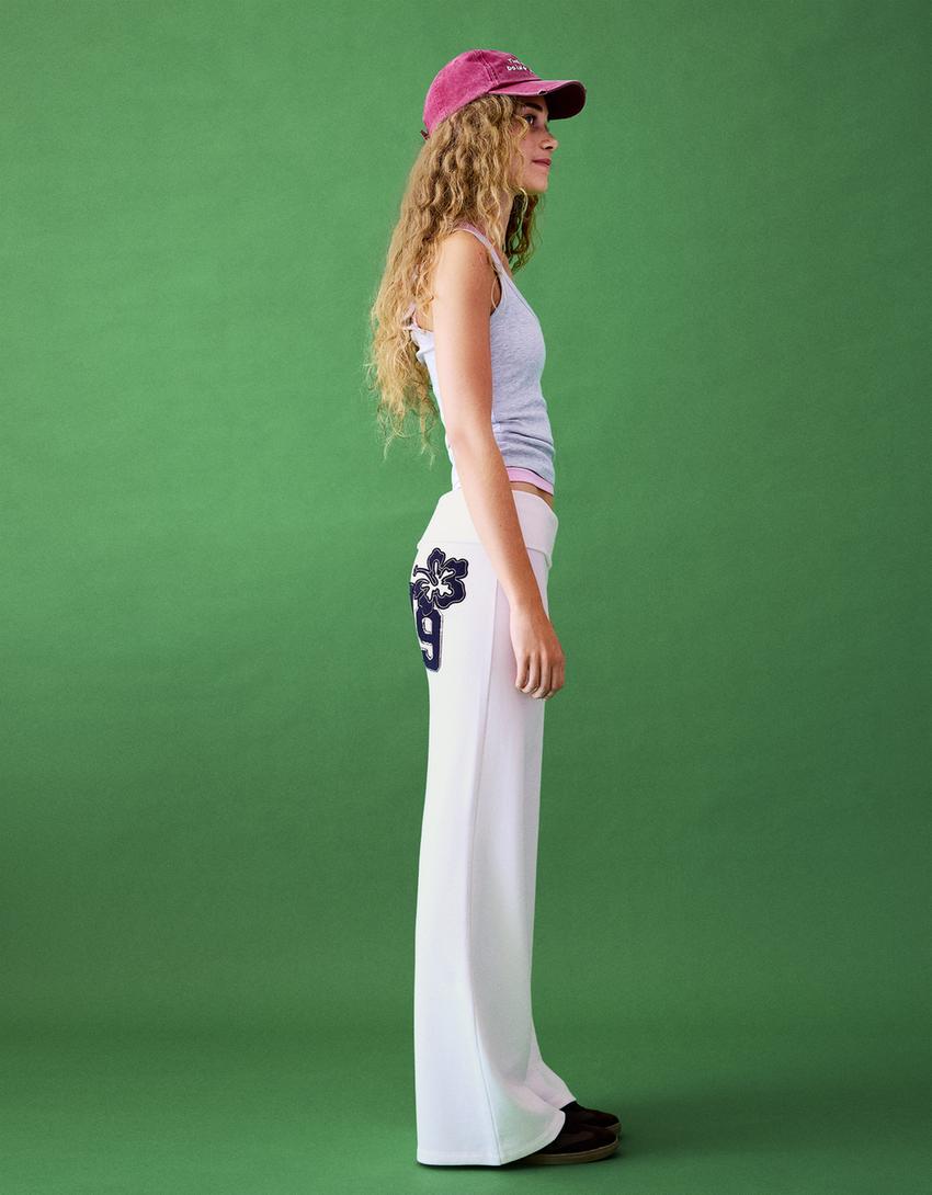 Flared plush trousers with patch-Cream
